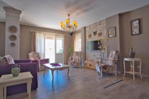 un salon avec un canapé et des chaises violettes dans l'établissement İonic Alaçatı, à Çeşme