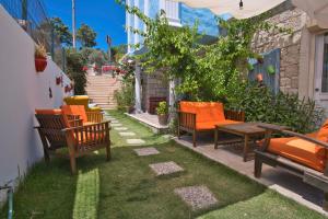 une terrasse avec des chaises et une table sur la pelouse dans l'établissement İonic Alaçatı, à Çeşme