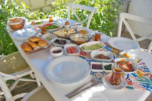 une table blanche avec des assiettes de nourriture dessus dans l'établissement İonic Alaçatı, à Çeşme