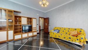 a living room with a yellow couch and a tv at House Antica Romana by Holiday World in Genoa