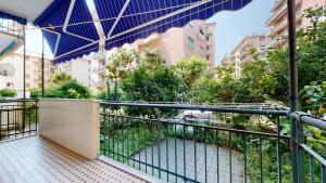 a balcony with a blue umbrella and some buildings at House Antica Romana by Holiday World in Genoa