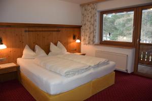 a bedroom with a large white bed with a window at Haus Marina in Sölden
