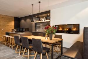 a kitchen with a wooden table and chairs and a fireplace at Mountain Chalet Kirchberg by Apartment Managers in Kirchberg in Tirol