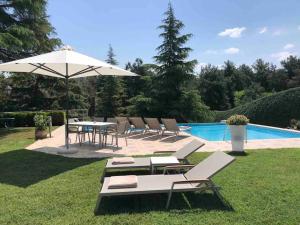 uma mesa e cadeiras com um guarda-sol ao lado de uma piscina em Villa Casa Chrissy em Plagiárion