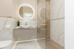 W łazience znajduje się szklana kabina prysznicowa i umywalka. w obiekcie Pozytywny Mokotów Apartment with Balcony Warsaw by Renters w Warszawie