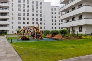 plac zabaw w parku z ławkami i budynkami w obiekcie Pozytywny Mokotów Apartment with Balcony Warsaw by Renters w Warszawie