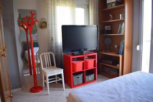 1 dormitorio con TV en un centro de entretenimiento rojo en Villa Casa Chrissy en Plagiárion