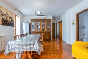 uma sala de jantar com uma mesa e um frigorífico em Viareggio Cozy Apartment with Balcony! em Viareggio