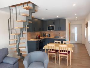 a kitchen and dining room with a spiral staircase at Ferienhaus Heidenest, mit E-Bike Vermietung in Buchholz in der Nordheide