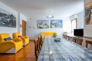 uma sala de estar com uma mesa de jantar e cadeiras amarelas em Viareggio Cozy Apartment with Balcony! em Viareggio