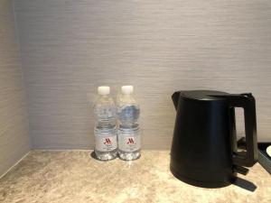 due bottiglie d'acqua sedute accanto a una macchinetta del caffè di Foshan Marriott Hotel a Foshan