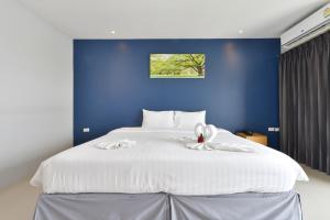 um quarto com uma grande cama branca e uma parede azul em VST Residence -SHA PLUS Certified em Ban Khlong Bang Ping