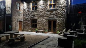 a patio with a table and benches in front of a building at Cadshaw Country Views in Darwen