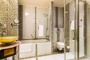 um banheiro com banheira, vaso sanitário e pia em Hotel Savannah em Chvalovice
