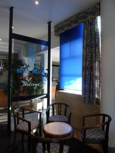 a restaurant with two chairs and a table and a window at Hotel Brasa in Elvas