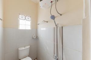 un bagno bianco con doccia e WC di RedDoorz Syariah at Sudirman Street Garut a Garut