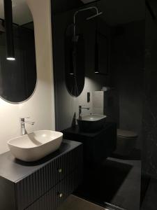 a bathroom with a white sink and two mirrors at MikroKlimat Premium in Jarosławiec