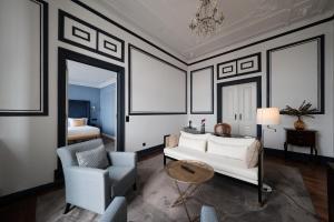 een woonkamer met een witte bank en een stoel bij Torel Palace Lisbon in Lissabon