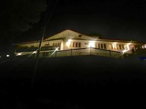 a house lit up at night with lights at LOUIS LAKE VILLA in Kandy