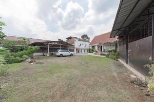 un'auto parcheggiata in un cortile accanto a un edificio di RedDoorz Syariah at Sudirman Street Garut a Garut