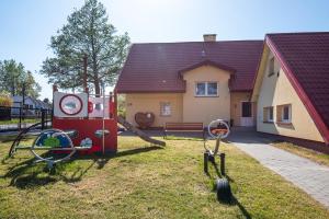 a house with a playground in the yard at Nad brzegiem Bałtyku in Sarbinowo