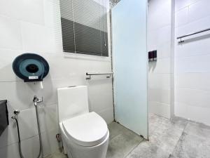 y baño blanco con aseo y ducha. en Jeff and Ricky Homestay 58@Vivacity Megamall, en Kampong Tabuan