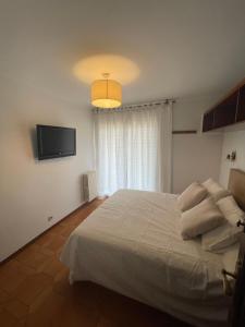 サン・フェリウ・デ・ギホルスにある1ra Linea Platja de Sant Feliuのベッドルーム(白いベッド1台、薄型テレビ付)