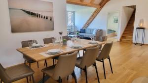 a dining room with a wooden table and chairs at Niesen Loft in Spiez