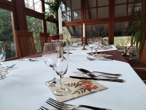 a table with glasses and silverware on a white table cloth at Dworek pod Herbem in Gądkowice