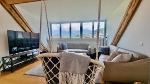 a living room with swing chairs and a television at Niesen Loft in Spiez