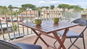 a wooden table with two coffee cups on a balcony at Apartamento Costamar by VACAY L'Escala in L'Escala