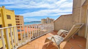 a balcony with two chairs and a view of the ocean at Apartamento Costamar by VACAY L'Escala in L'Escala