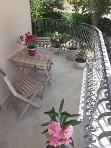 un patio avec un banc, une table et des plantes en pot dans l'établissement La casetta di rosario mondello, à Palerme