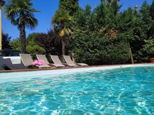 eine Gruppe von Stühlen neben einem Pool in der Unterkunft Villa delle palme B&B 5 stelle in Carpi