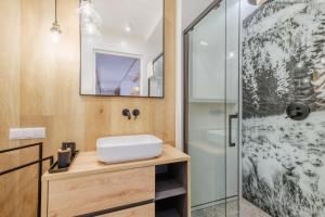 uma casa de banho com um lavatório e um chuveiro em Apartament RELAKS - komfortowy apartament z bezpłatnym jacuzzi, sauną oraz podziemnym parkingiem w cenie em Zakopane