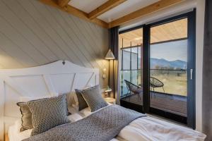 um quarto com uma cama e uma grande janela em Apartament RELAKS - komfortowy apartament z bezpłatnym jacuzzi, sauną oraz podziemnym parkingiem w cenie em Zakopane