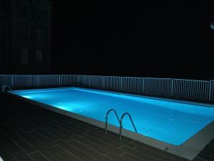 a swimming pool lit up in the dark at ChâtEscos - Estudio en Château in Escos