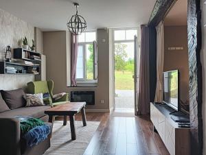 a living room with a couch and a tv at ChâtEscos - Estudio en Château in Escos