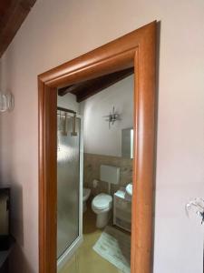 a bathroom with a toilet and a glass door at SinyHouse in Terrasini