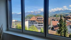 a group of windows with a view of mountains at Niesen Loft in Spiez
