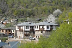 un grupo de casas en una ciudad con una montaña en Leshtenski Perli, en Leshten