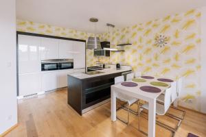 Apartment FAMILY Bratislava في براتيسلافا: مطبخ بطاولة بيضاء ومطبخ بجدران صفراء