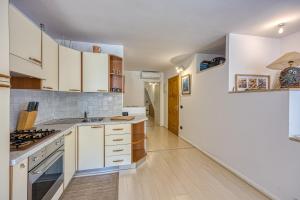 a kitchen with white cabinets and a white refrigerator at Astra 1 Veli Lošinj Harbour View - Happy Rentals in Veli Lošinj