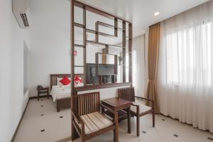 a hotel room with a bed and a table and chairs at Praha Hotel Phú Quốc in Phú Quốc