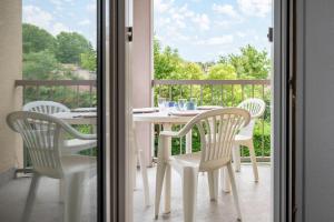 d'une table et de chaises blanches sur un balcon. dans l'établissement T2 Rangueil - Terrasse + 2 Parkings - 4 personnes, à Toulouse