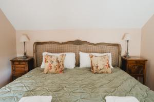 een slaapkamer met een bed met kussens en 2 nachtkastjes bij Lodge Cottage, Castleton in Castleton