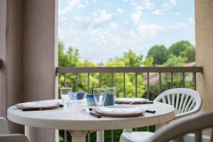 een witte tafel met borden en glazen op een balkon bij T2 Rangueil - Terrasse + 2 Parkings - 4 personnes in Toulouse
