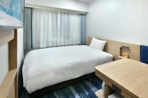 名古屋市にある名古屋栄ワシントンホテルプラザのベッドと窓が備わる小さな客室です。