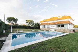 a swimming pool in the yard of a house at La Casona Imperial in Alpedrete