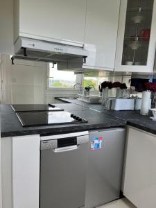 a kitchen with white cabinets and a stove top oven at Apartment HOME in Paris with View, 15min to center in Paris
